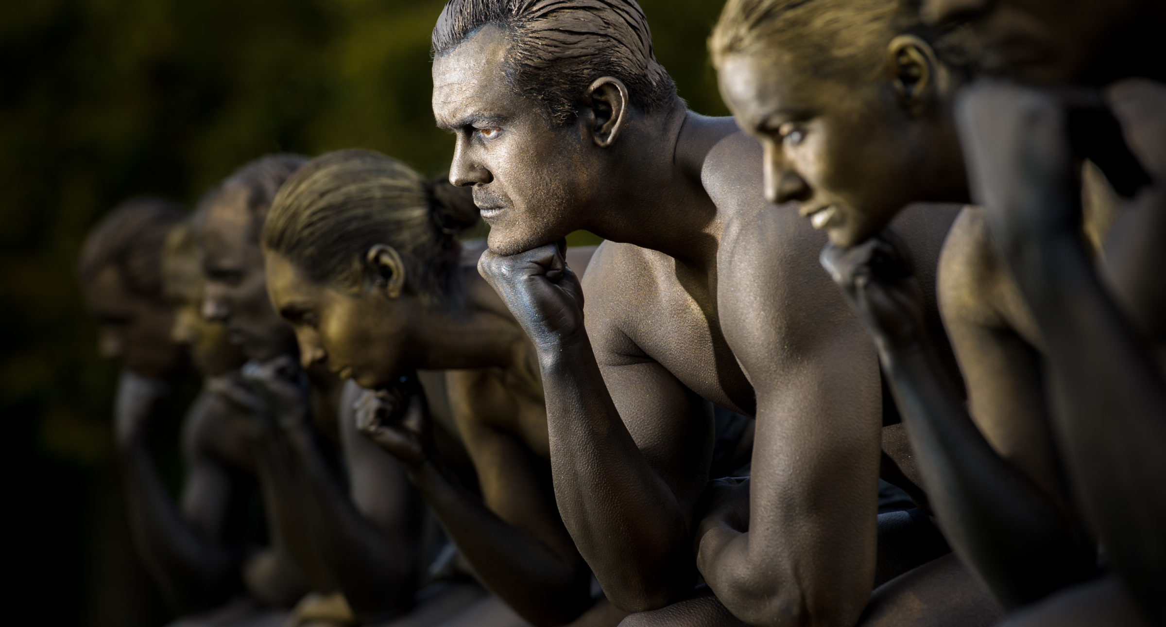 Nine models posed as Rodin's Thinker